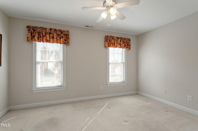 unfurnished room featuring light carpet, ceiling fan, visible vents, and baseboards