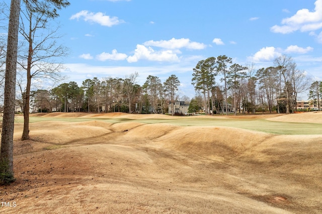 view of community with golf course view and a lawn