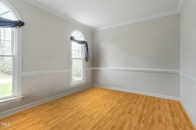 unfurnished room with baseboards, light wood-style floors, and crown molding