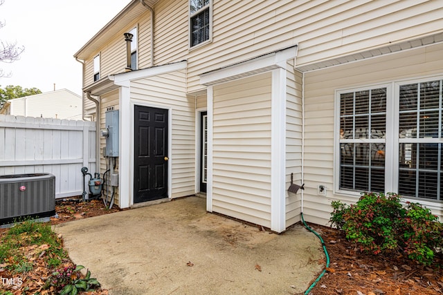 doorway to property featuring a patio area, fence, and central AC unit