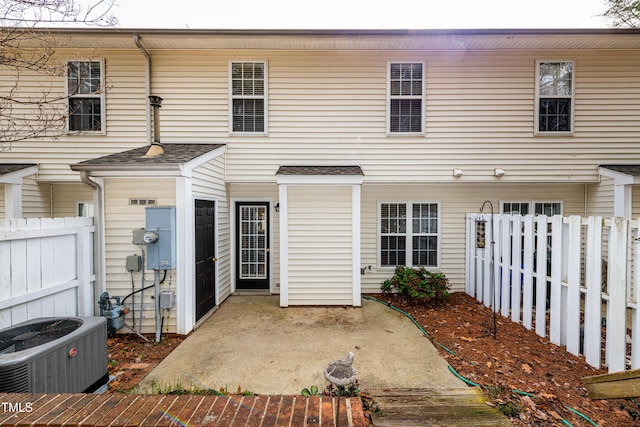 view of front of house featuring fence, central AC, and a patio