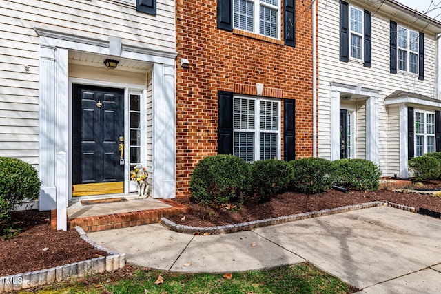 entrance to property featuring brick siding