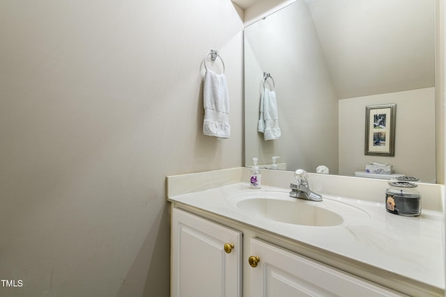 half bathroom with vaulted ceiling and vanity