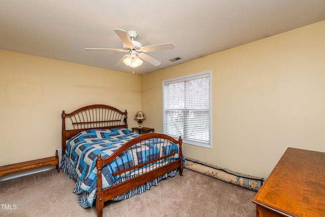 carpeted bedroom featuring a ceiling fan and visible vents