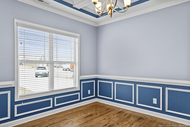 spare room featuring crown molding, a chandelier, a wealth of natural light, and wood finished floors