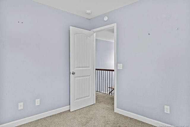 carpeted empty room with baseboards