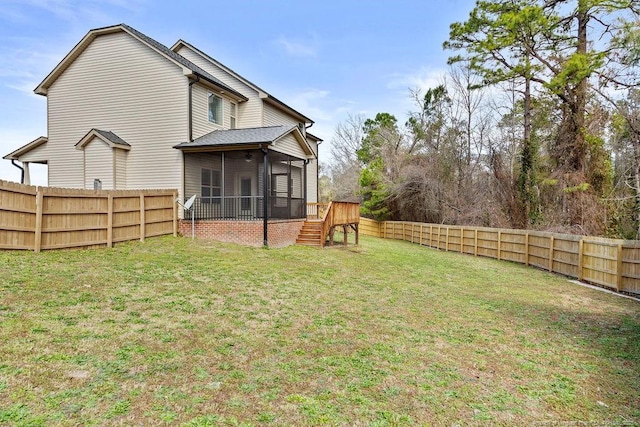 rear view of house with a sunroom, a fenced backyard, and a lawn