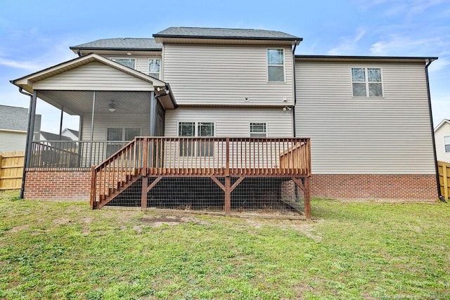 rear view of property featuring a deck, a lawn, stairs, and fence