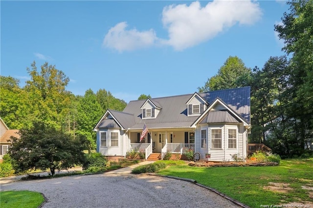 view of front of house featuring covered porch, metal roof, and a front yard