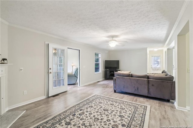 living room featuring a textured ceiling, ceiling fan, and light wood-type flooring