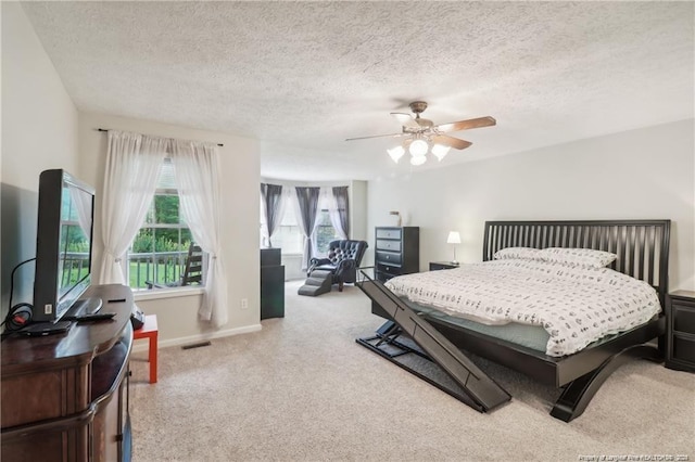 bedroom featuring visible vents, baseboards, ceiling fan, a textured ceiling, and carpet floors