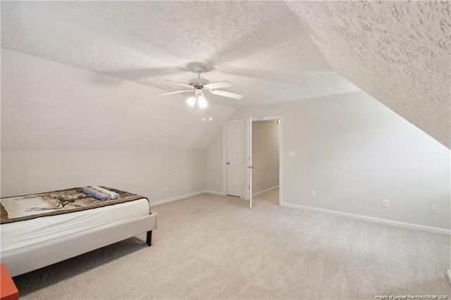 bedroom with light carpet, vaulted ceiling, a textured ceiling, and baseboards