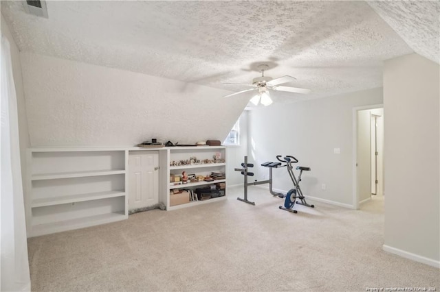 workout area featuring baseboards, lofted ceiling, ceiling fan, a textured ceiling, and carpet floors