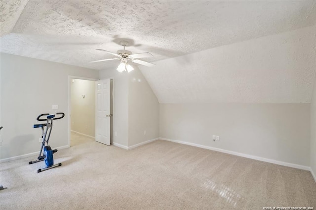 workout room with carpet, vaulted ceiling, and a textured ceiling