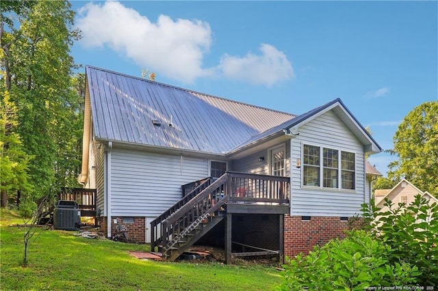 rear view of property featuring a lawn, stairway, crawl space, metal roof, and a wooden deck