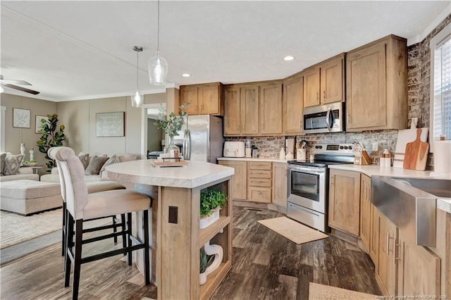 kitchen featuring stainless steel appliances, open floor plan, a kitchen island, and backsplash