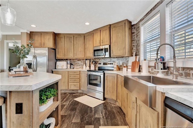 kitchen with stainless steel appliances, backsplash, a sink, and light countertops