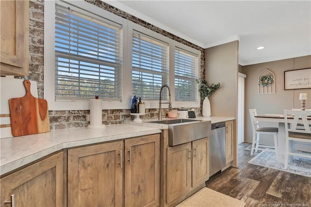 kitchen with dark wood finished floors, light countertops, dishwasher, and a sink