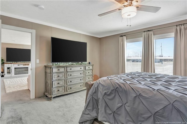 bedroom with a ceiling fan, light carpet, and a textured ceiling