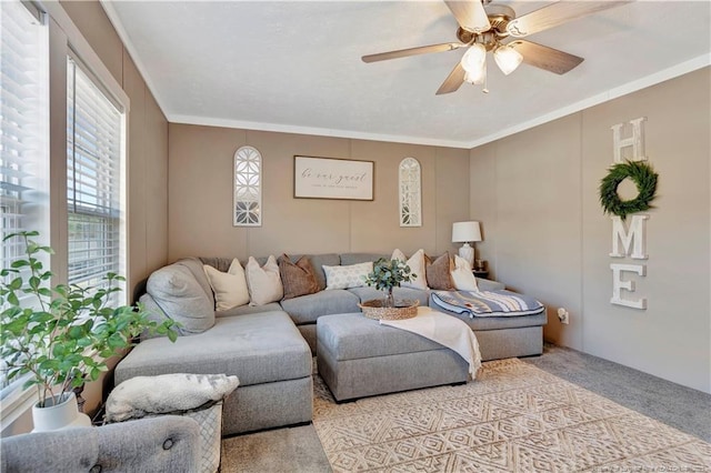 living room with ornamental molding, light colored carpet, and a ceiling fan