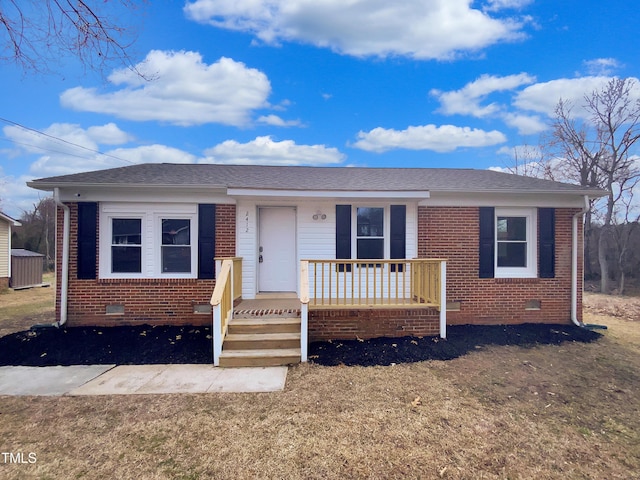 view of front of house with crawl space, covered porch, a shingled roof, and brick siding