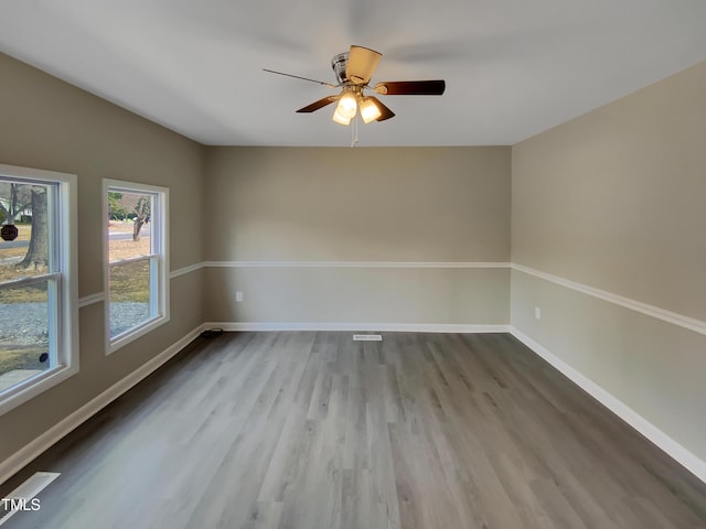 unfurnished room featuring wood finished floors, a ceiling fan, and baseboards