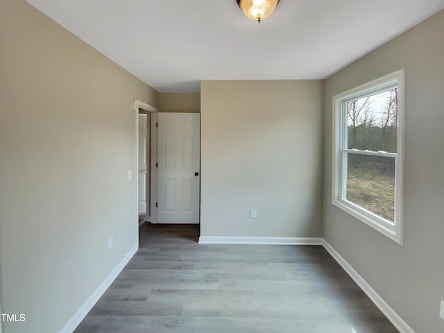 empty room with baseboards and wood finished floors