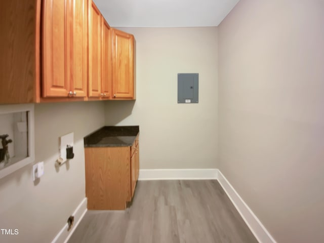 laundry area featuring cabinet space, electric panel, baseboards, wood finished floors, and hookup for a washing machine