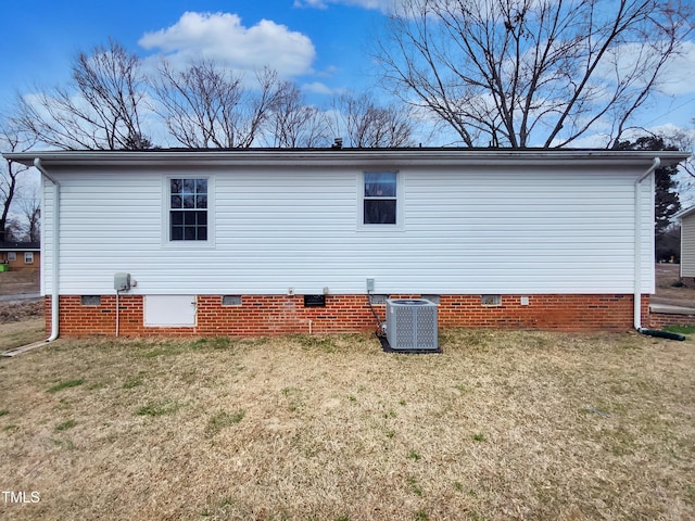 view of home's exterior featuring crawl space, a lawn, and central AC