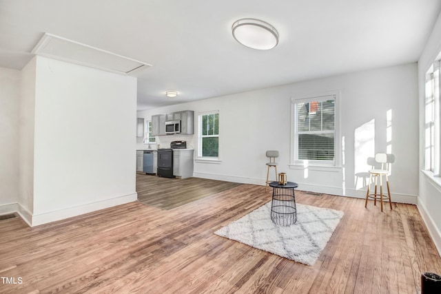 interior space featuring attic access, baseboards, and light wood-style flooring