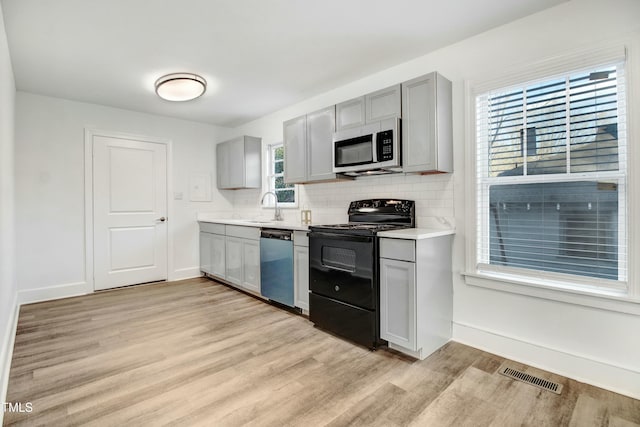 kitchen with visible vents, stainless steel microwave, electric range, a sink, and dishwasher