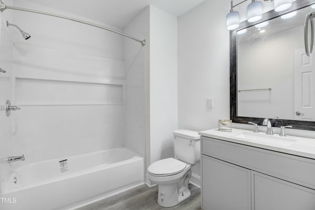 full bath featuring bathtub / shower combination, vanity, toilet, and wood finished floors