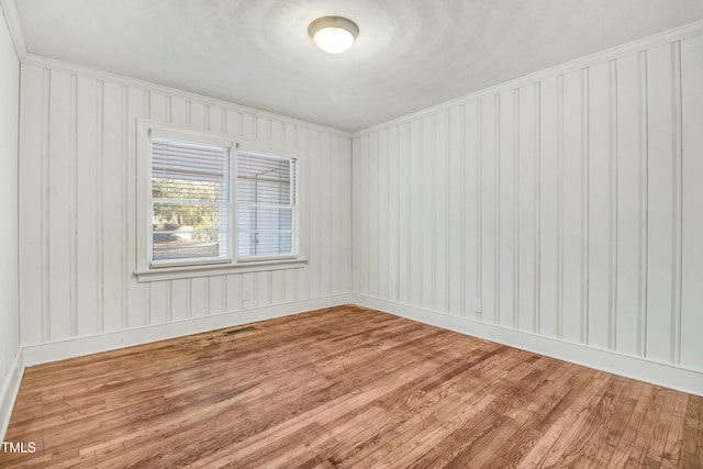 spare room featuring wood finished floors and baseboards