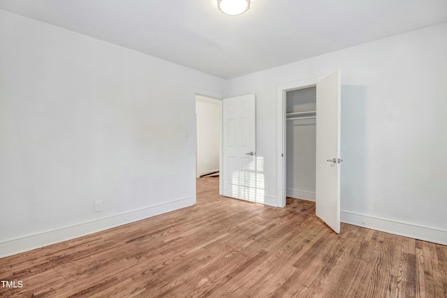 unfurnished bedroom with a closet, baseboards, and wood finished floors