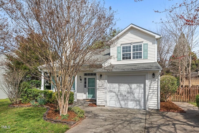 traditional-style house featuring a garage, roof with shingles, concrete driveway, and fence