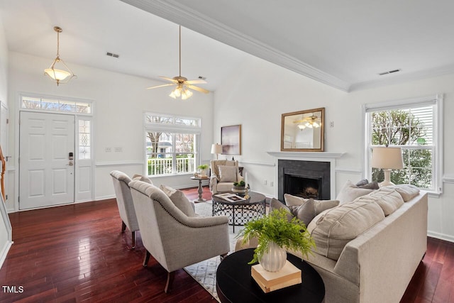 living room with a ceiling fan, dark wood-type flooring, a fireplace, and visible vents