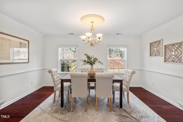 dining room featuring an inviting chandelier, wood finished floors, visible vents, and baseboards