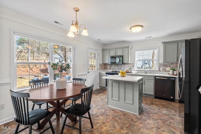 kitchen with stainless steel microwave, gray cabinetry, light countertops, dishwashing machine, and freestanding refrigerator