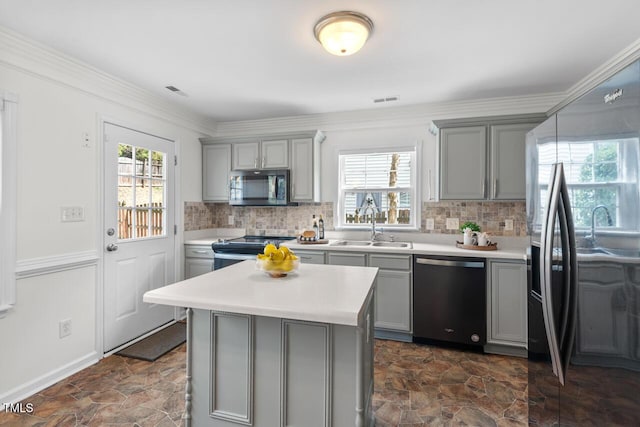 kitchen featuring backsplash, appliances with stainless steel finishes, gray cabinets, and light countertops