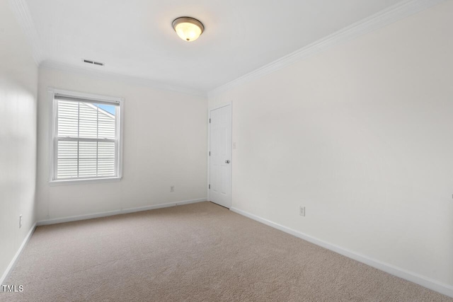 spare room featuring carpet flooring, visible vents, baseboards, and ornamental molding