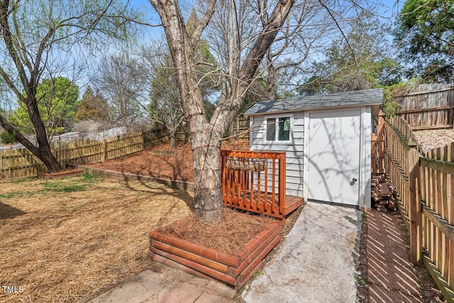 view of yard with an outbuilding, a fenced backyard, and a shed