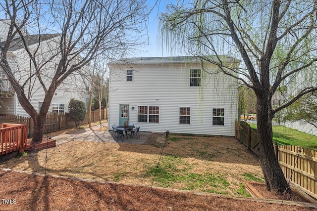 rear view of property featuring a patio and a fenced backyard