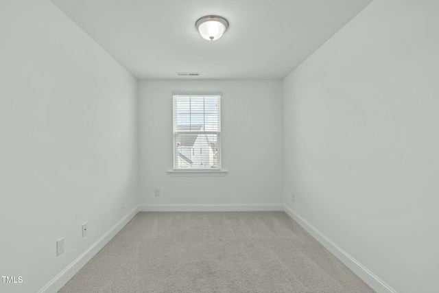 unfurnished room featuring carpet, visible vents, and baseboards