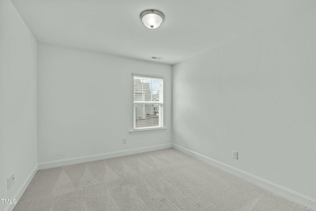 empty room featuring light carpet, baseboards, and visible vents