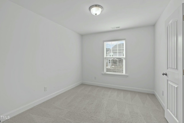 empty room featuring light carpet, baseboards, and visible vents