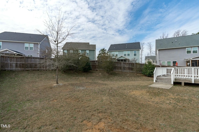 view of yard featuring a residential view, a fenced backyard, and a deck