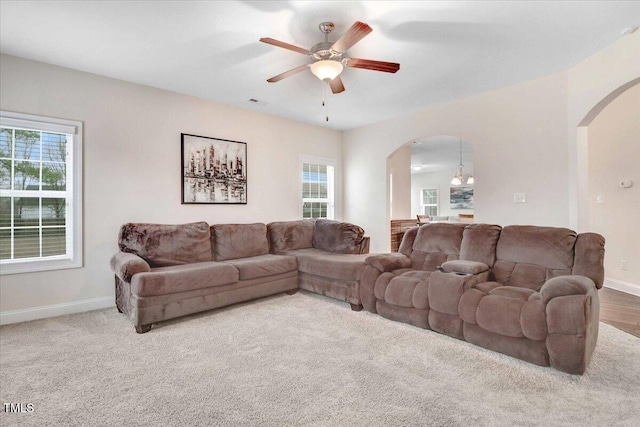 living area with arched walkways, plenty of natural light, and baseboards