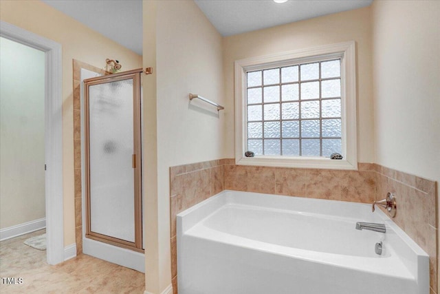 bathroom with a stall shower and a bath