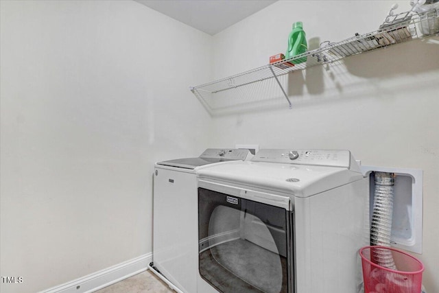 laundry room featuring laundry area, separate washer and dryer, and baseboards