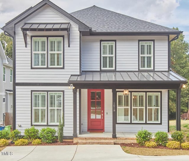 view of front of home with metal roof, a porch, a standing seam roof, and a shingled roof